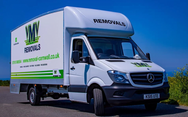 YMV removals van parked on a road, featuring a white exterior with green branding, ideal for moving services in Cornwall.